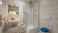 Geräumiges Badezimmer mit gläserner Regendusche